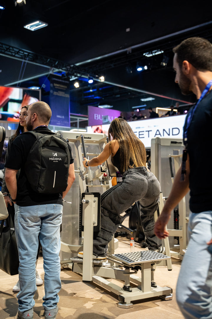 Athlete using the Gluteleader Standing Abductor GL-1005 at a fitness exhibition